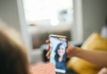 Quatre utilisateurs, zéro churn : le retour du logiciel situé Un enfant montre un dessin devant un téléphone posé sur une table, en visio avec un proche, dans un salon