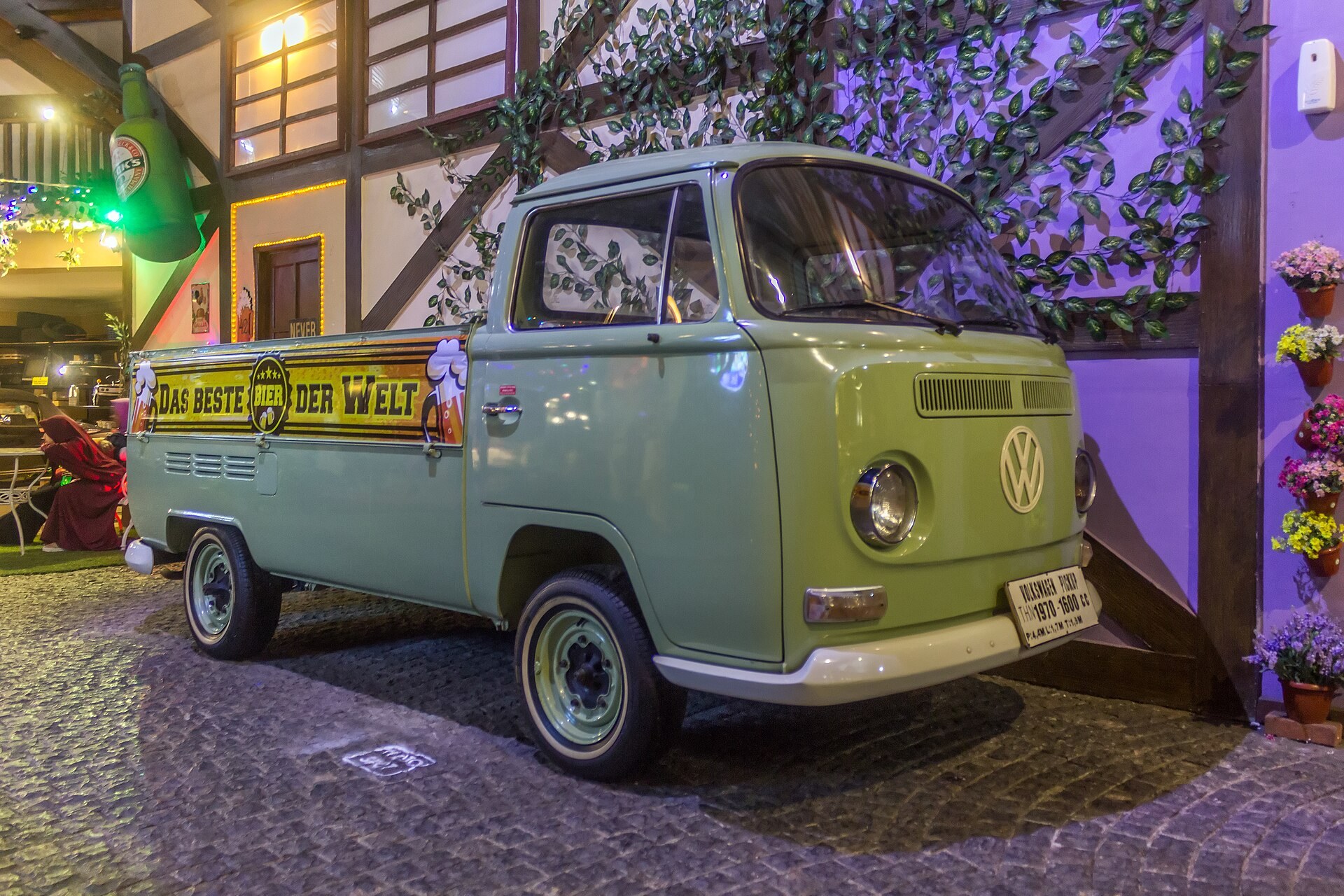 Une camionnette plateau Volkswagen Type 2 vert pale de 1970 exposee dans un musee.