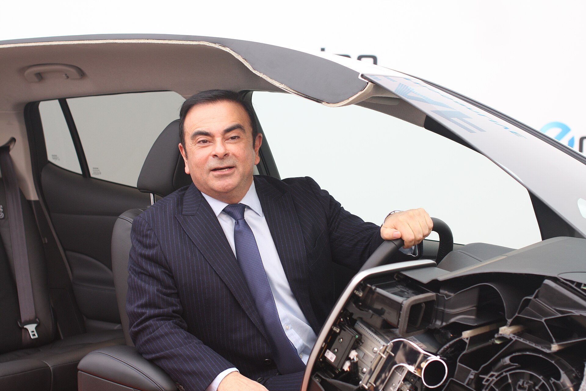 Carlos Ghosn assis au volant d une voiture electrique.