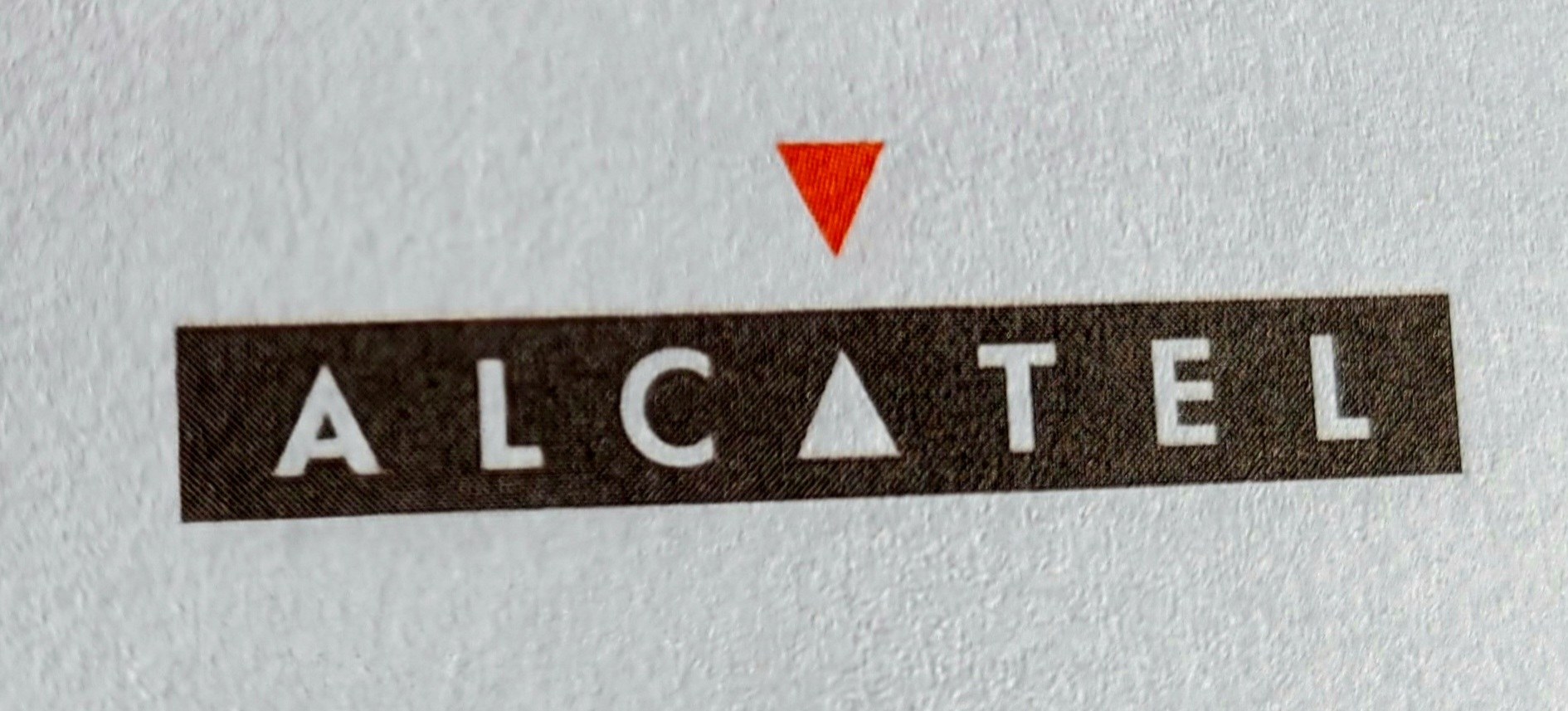 Le logo Alcatel, lettres claires sur fond sombre, avec un triangle rouge.
