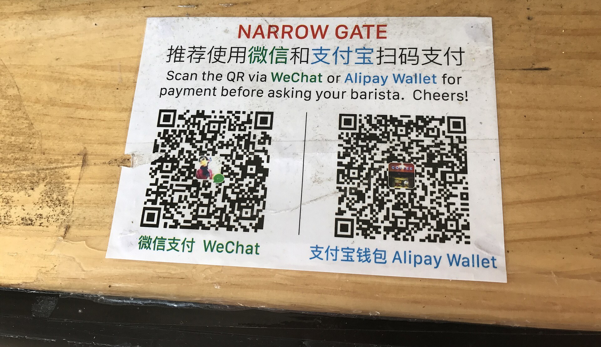 Un panneau de comptoir avec deux codes QR de paiement, WeChat et Alipay.