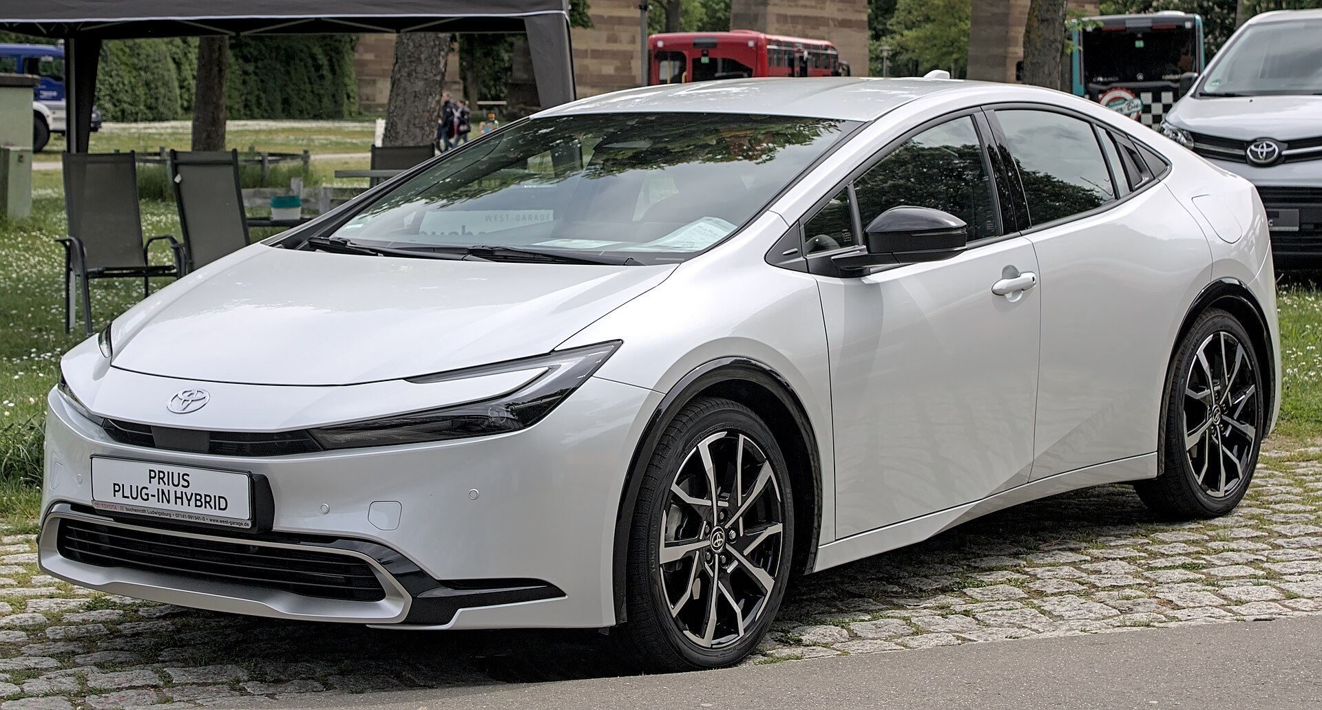 A white Toyota Prius plug-in hybrid on display at a motor show.