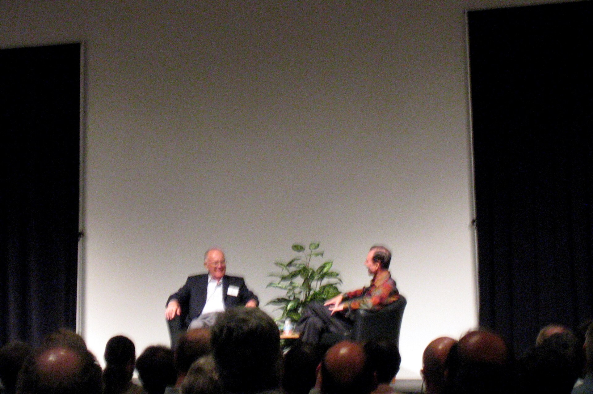 Two men seated on a stage in front of an audience, at the Computer History Museum.