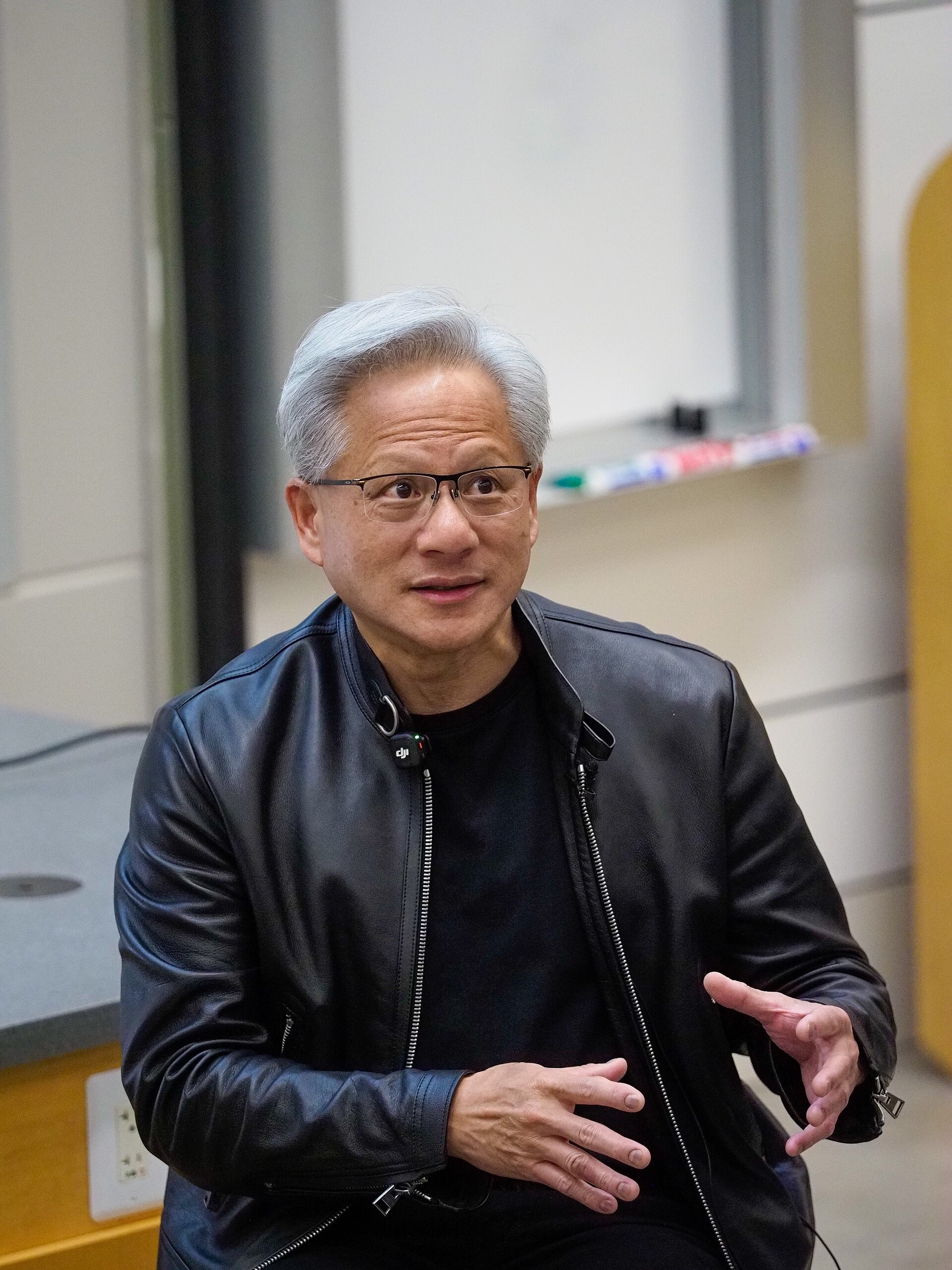 Jensen Huang in a leather jacket speaking in front of students.