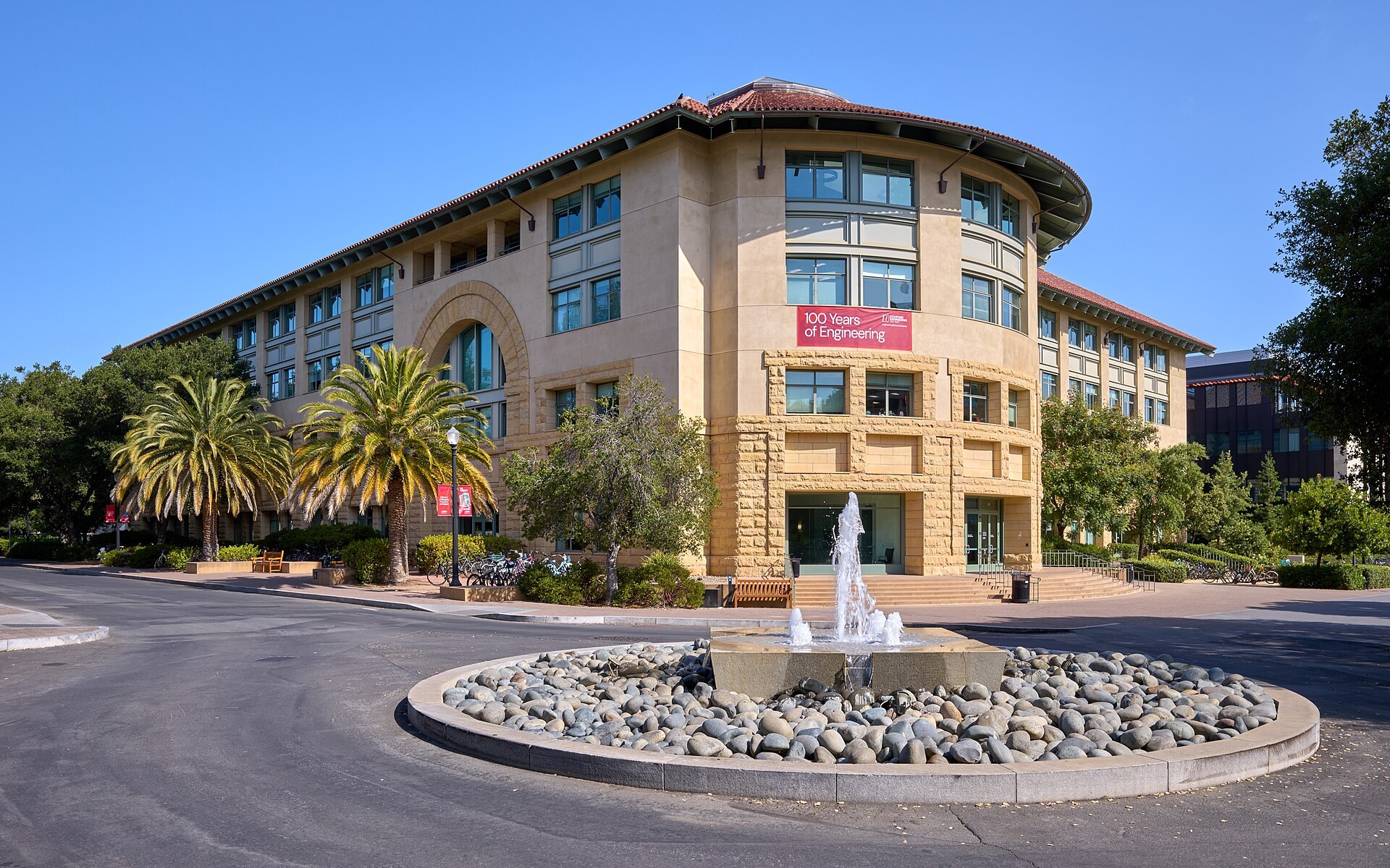 Stanford University's Gates computer science building, with a fountain in the foreground.