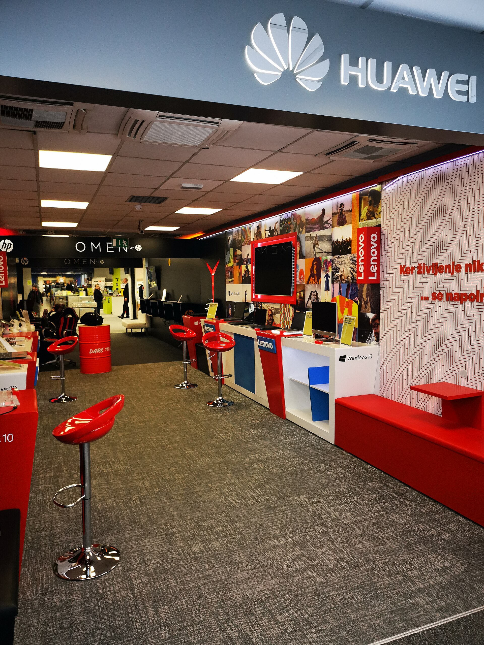L interieur d une boutique Huawei, avec des tabourets rouges et des presentoirs.