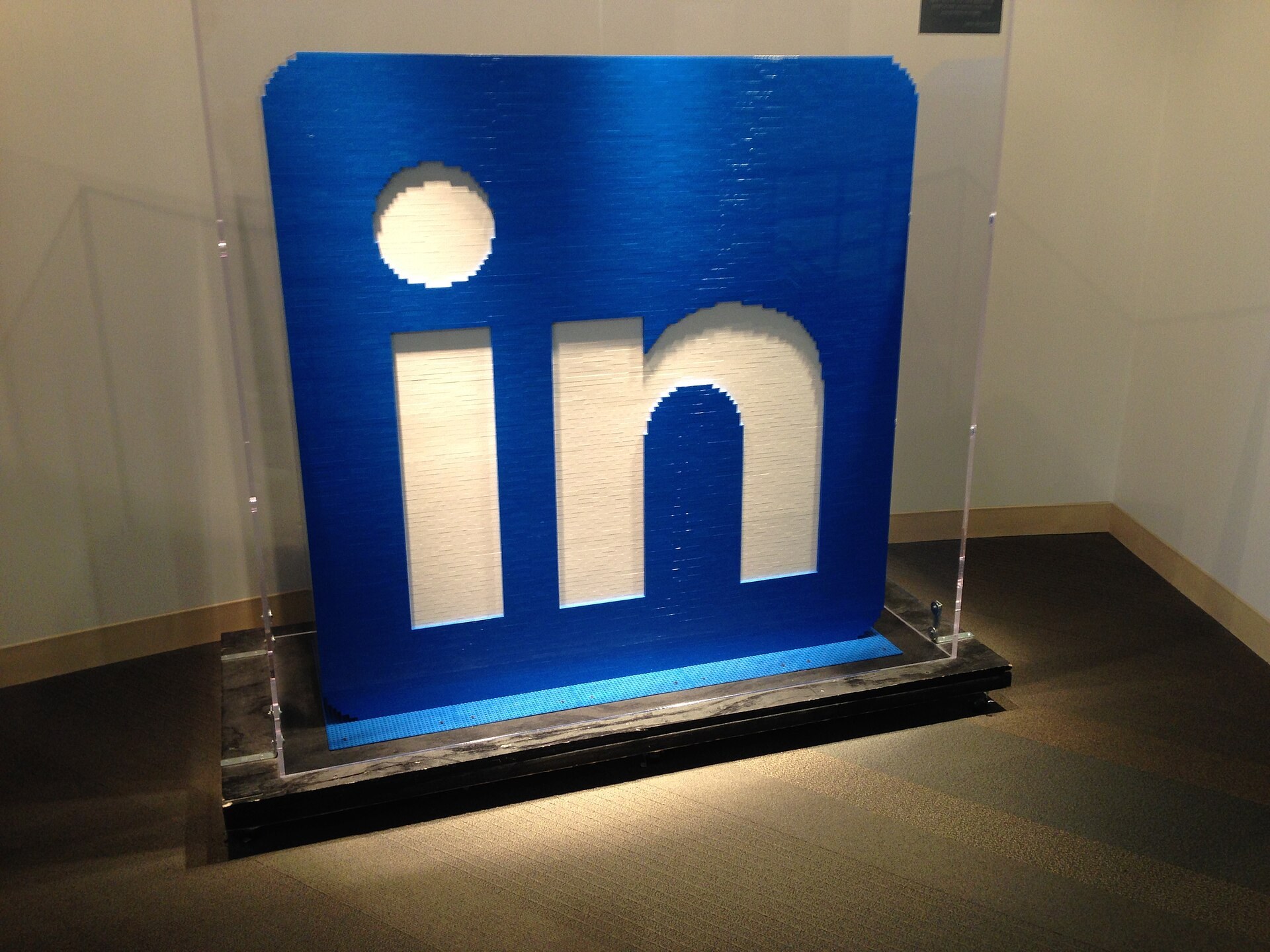 Le logo de LinkedIn en relief, bleu et blanc, expose dans un bureau.