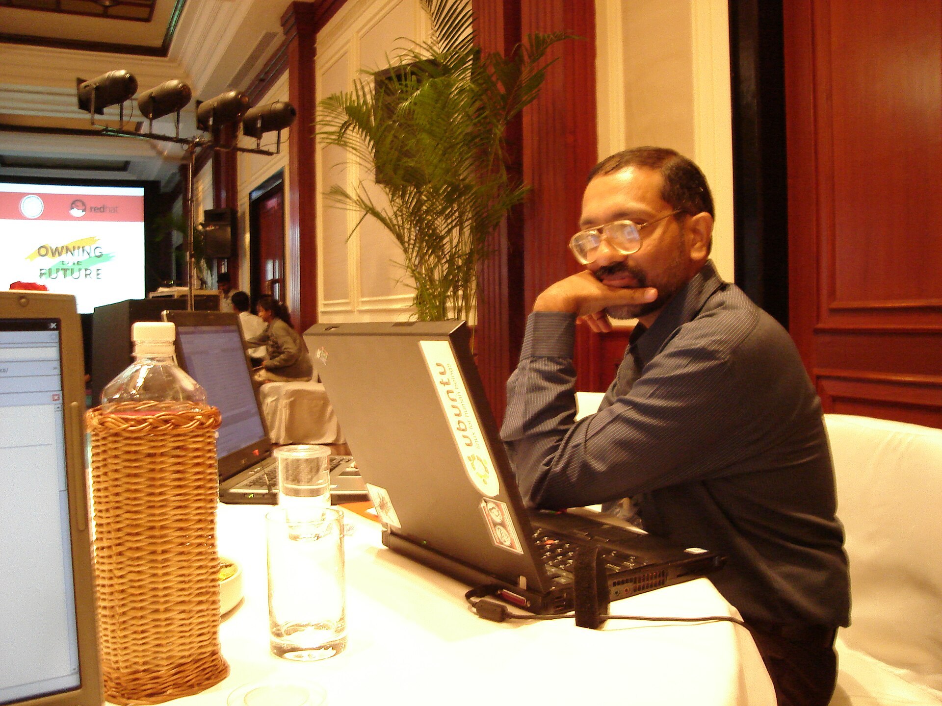 Un participant assis devant son ordinateur portable lors d'une conférence.
