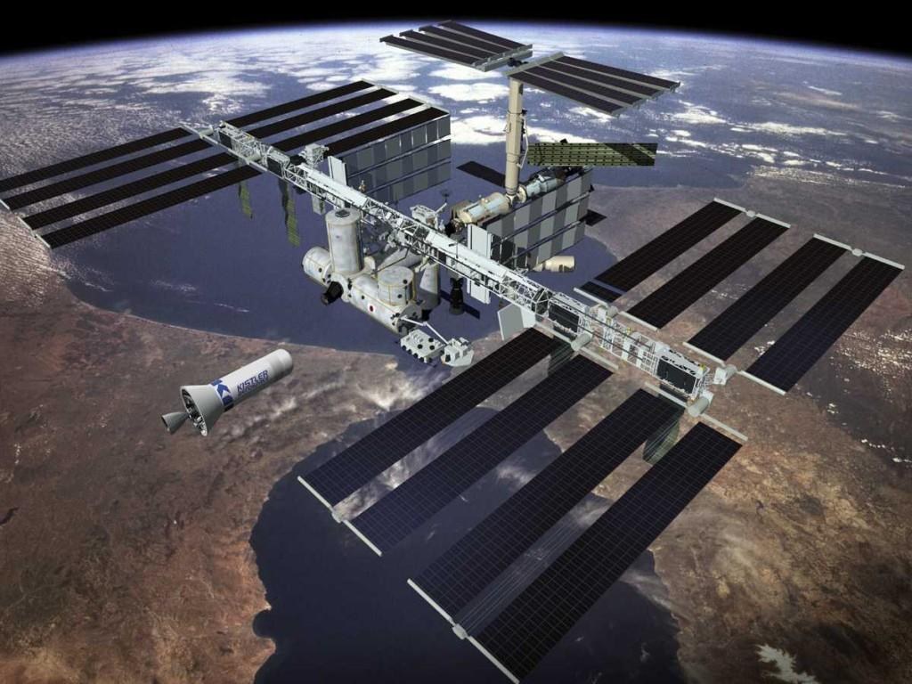 Image de synthese : l etage superieur du lanceur K-1 approche la Station spatiale internationale au-dessus de la Terre.