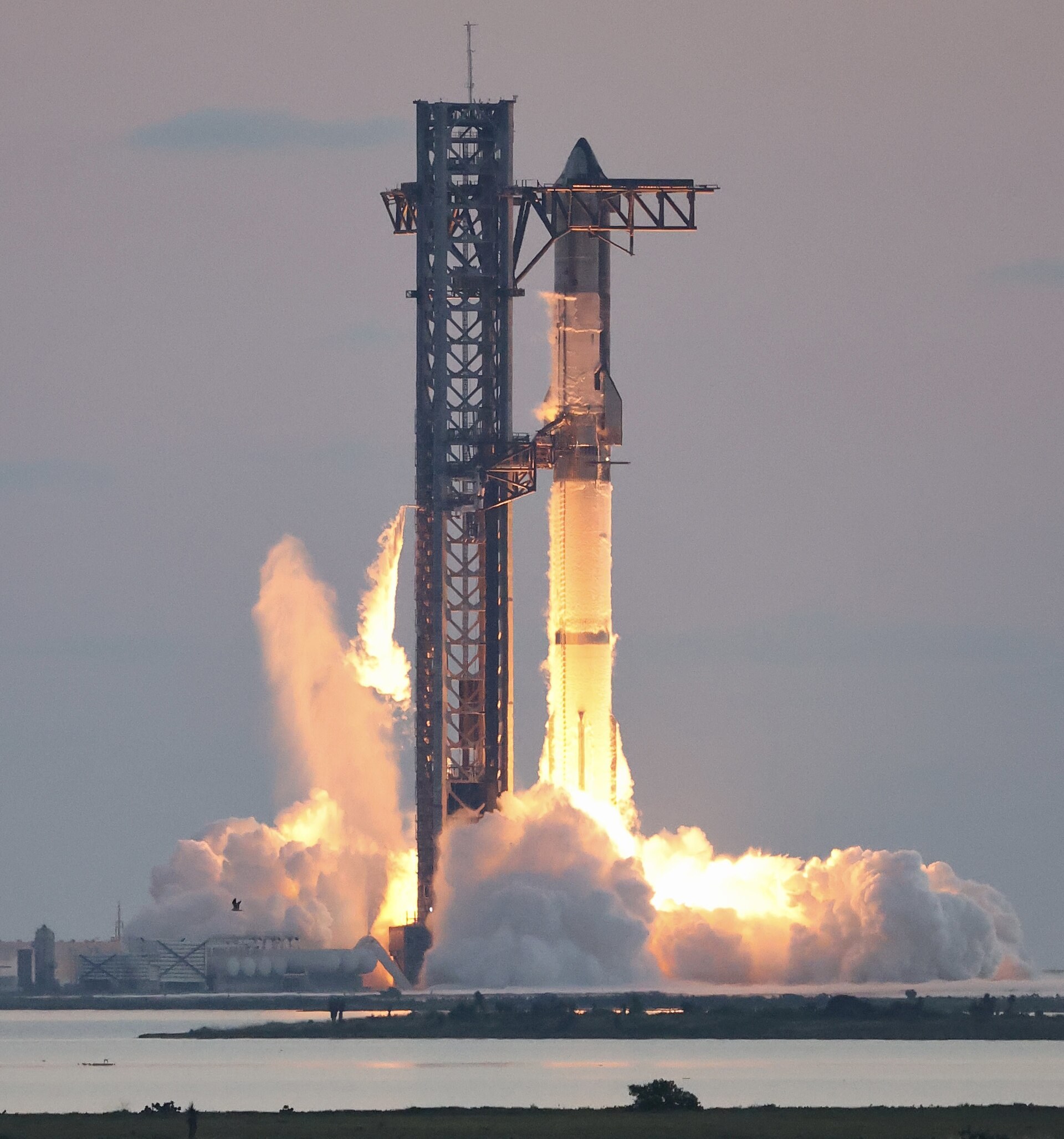 La fusee Starship s allume sur son pas de tir dans un grand nuage de flammes.