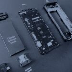 Les modules détachés d’un téléphone Fairphone 3 posés sur un présentoir noir, en bichromie bleu sombre