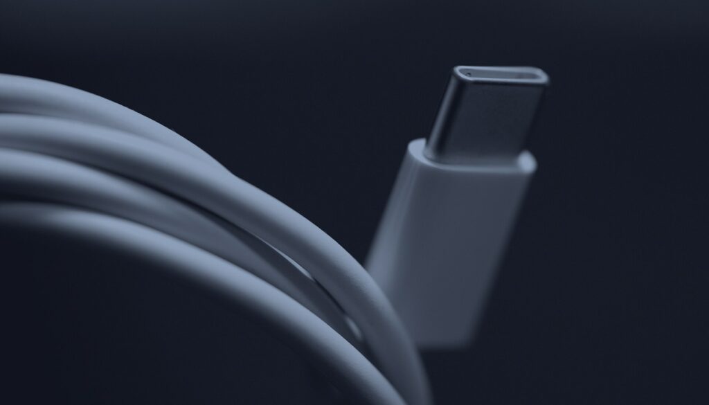 Un câble USB-C blanc et son connecteur en gros plan, en bichromie bleu sombre