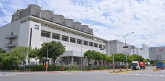 Nvidia ne doit rien à personne, sauf le sol sur lequel elle est bâtie L'usine Fab 18 de TSMC dans le parc scientifique du sud de Taïwan, vue depuis la rue, avec ses tours de refroidissement sur le toit et des camions à l'entrée
